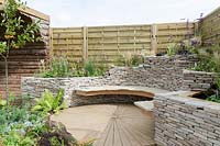 Curved stone bench set in a dry stone wall surrounded by a timber fence - 'Traditional Modernism', The Bath and West Garden Show 2012