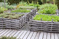 Formal herb garden with planted squares woven around the sides. Jardin des Cimes, Chamonix, France. July