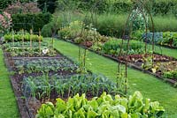Kitchen garden with raised beds of lettuces, cabbages. beans, spinach, sweet corn, carrots, beetroot and marigolds.