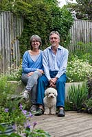Laura Wahburn Hutton, cookery writer, and Ian Pollock in their London garden with Ted, a bichon frise dog.