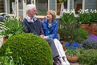 Tony and Julie Peckham in their late spring garden, sitting on the steps in front of a new summerhouse.