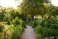 Formal, ornamental potager with box edged beds, box cones, soft fruit standars, Juglans regia and pavilion with variegated ivy - May, Herrenmühle Bleichheim