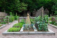 View of the potager at le Prieuré Notre Dame d'Orsan with raised beds built with railway sleepers and structures made with bamboo and chestnut