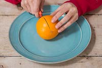 Slice the Orange in half over a plate