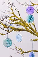 Painted Clay decorations with imprints of Pine foliage, hanging from a branch covered in Lichen