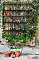 veiw of wooden shelves with raised bed in court yard. Lucille Lewins, small office court yard garden in Chiltern street studios, London. Designed by Adam Woolcott and Jonathan Smith