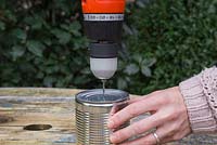Drilling water drainage holes in an Aluminium can