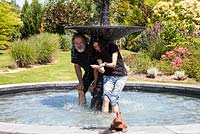Renate-Elisa and Lutz Hillen having fun in the fountain of their Italian garden - July, Les Jardins de la Poterie Hillen