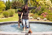 Renate-Elisa and Lutz Hillen having fun in the fountain of their Italian garden - July, Les Jardins de la Poterie Hillen