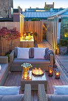 Outside seating area leading onto bbq area at dusk on a London roof terrace. April. 