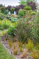 Phormium 'Tom Thumb' and Libertia ixioides 'Goldfinger' at Bhudevi Estate garden, Marlborough, New Zealand.
