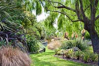 Large willow trees and other native grasses and shrubs at Bhudevi Estate garden, Marlborough, New Zealand.
