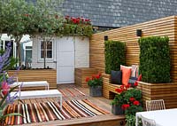 Back garden with carpets, decking, deck chairs, shed and loungers, London, summer - Ben De Lisi house and garden. 