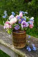 Anemones and mysotitis with apple blossom displayed in pottery vase