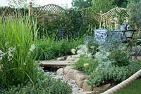 'The Drought Garden', The garden's central feature is a waterless river bed of pebbles, traversed by a yorkstone 'plank' and edged with irregular shaped blocks of purbeck stone. Plants include Verbena bonariensis, Verbascum 'Kynaston', Eryngium 'Jos Eiking', Pennisetum villosum and alopecuroides 'Hameln', Stipa gigantea, Gaura lindheimeri 'Whirling Butterflies', artemisia, stachys and hebe.   Best City Garden: Hampton Court Flower Show, July 2016.