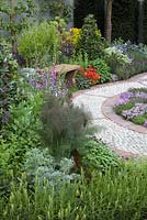 The St John's Hospice - A Modern Apothecary,  peaceful seating area with cobbled path, surrounded by herbs, including bay, fennel, lavender and sage - Designer: Jekka McVicar - RHS Chelsea Flower Show, 2016.
