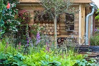 Bug hotels surrounded by planting in the RHS Greening Grey Britain for Health, Happiness and Horticulture Garden. RHS Chelsea Flower Show 2016 - Designer: Annie-Marie Powell