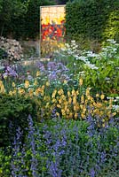 God's Own County - A Garden for Yorkshire - The planting in the bed includes orange Verbascum, Nepeta racemosa 'Walker's Low' and Euphorbia 'Redwing' while a glass panel in the background echoes the East Window's York Minster. RHS Chelsea Flower Show 2016, Designer: Matthew Wilson, Sponsor: Welcome to Yorkshire