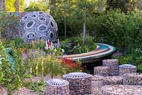 The Brewin Dolphin Garden - Forever Freefolk.  A view of lush late spring perennial borders with gabions, inspired by a dry chalkstone river bed. RHS Chelsea Flower Show 2016. Designer: Rosy Hardy, Sponsors: Brewin Dolphin