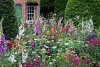 The Harrods British Eccentric Garden. Cottage garden with spring flowering perennials. RHS Chelsea Flower Show 2016, Designer: Diarmuid Gavin, Sponsor: Harrods