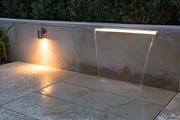 Water feature built into sandstone patio wall with the addition of downlight lighting