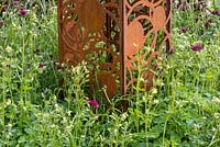 Corten Steel panel sculpture surrounded by Aquilegia 'Green Apples' and Cirsium rivulare 'Atropurpurea', The Sunken Retreat, RHS Malvern Spring Festival 2016. Design: Ann Walker, Graduate Gardeners