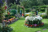 Colourful mixed beds filled shrubs, perennials and tender bedding plants, including Lobelia, Calendula, Begonia, Clematis, Achillea, Leucanthemum and Rosa. 