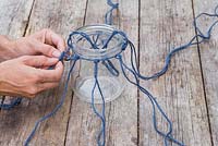 Begin to weave the different strands of string together to form the net mesh