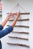 Weave the string between the Hazel sticks to strengthen the trellis
