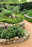 Herb spiral made of stones with Mentha x piperita, Satureja montana, Lavandula angustifolia and Rosmarinus officinalis'Le jardin qui se savoure' designed by Guillaume Popineau, David Trigolet and Chantal Dufour at the Festival International des Jardins 2016, Chaumont-sur-Loire, France