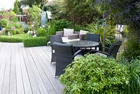 Rattan furniture on decking in suburban garden 