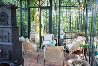 Wicker chairs and historic iron oven inside the Art Deco glasshouse