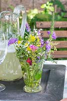 Bunch of wildflowers and glass jug with homemade lemonade and on a tray, Galium, Knautia arvensis, Leucanthemum vulgare, Silene armeria, Vicia cracca