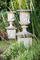 A pair of urns mark the entrance to the privet walk.