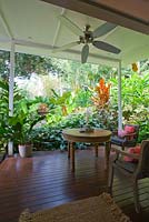 Outdoor deck with timber seating a ceiling fan at a Bed and Breakfast accommodation in tropical northern Australia. 