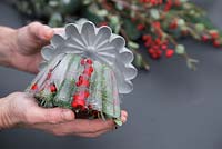 Removing the Jelly mould from the frozen Pine foliage, Eucalyptus and Ilex verticillata berries