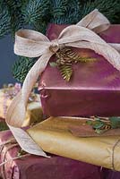 A variety of wrapped presents with Fern foliage and Eucalyptus, with spray painted imprint of a Fern