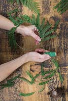 Use string to secure the fern fronds to the wreath
