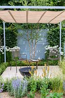 Steel louvred panels and  pergola with retractable canopy, with a barbecue and seating. Final 5 'Retreat Garden',Hampton Court Flower Show, July 2016