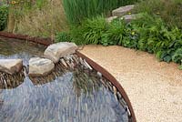 Stream banked by grasses and wildflowes in the Zoflora Outstanding Natural Beauty Garden at RHS Hampton Court Flower Show 2016