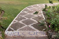 Concrete path with blue tile insets through garden with borders and lawn - Lake Atitlan Hotel, Guatemala