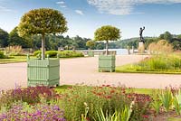 The Italian Garden at Trentham Gardens, Staffordshire - designed by Tom Stuart-Smith. The statue of Perseus and Medusa is in the background next to the lake created by Capability Brown. Planting includes Portuguese Laurels in planters, Penstemons, Knautia macedonica, Achillea and Stipa gigantea
