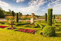 A view over the formal Upper Flower Garden at Trentham Gardens, Staffordshire. Planting includes Pelargoniums, Begonias, Stipa gigantea, Buxus and fastigate Irish yews