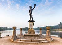 A replica of the statue of Perseus and Medusa by sculptor Benevenuto Cellini at Trentham Gardens, Staffordshire - with the lake at Capability Brown landscape in the background