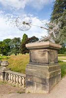 A life sized fairy, called 'Wishes' stands on a plinth beside the lake at Trentham Gardens, Staffordshire. it commemorates the first ten years of the garden's regeneration. The artwork was created by Robin Wight from galvanised and stainless steel wire