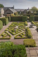 A view to the house across The Fancy Garden with its Tudor rose pattern made from box - June, Herterton House, Hartington, Northumberland, UK 
