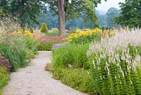 A path through the Floral Labyrinth at Trentham Gardens, Staffordshire, designed by Piet Oudolf. Photographed in summer planting includes Stipa gigantea, Knautia macedonica, Veronicastrums and Persicaria