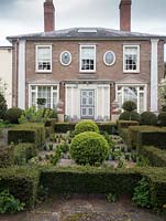 The Laskett Gardens- The house from Howdah court with Taxus baccata hedge and topiary balls.