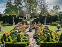 The Laskett Gardens- The Silver Jubilee garden with Tulipa, urn planters and spring flowers enclosed within buxus hedging.