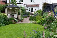The semi-detached 1920s house overlooks a 24m x 7.6m, gently sloping back garden with patio, gazebo and circular lawn enclosed in cottage style borders.